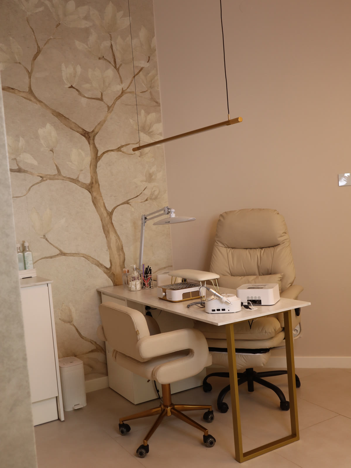 Stanowisko do stylizacji paznokci w New Essence, ściana z malowaną magnolią i złote detale